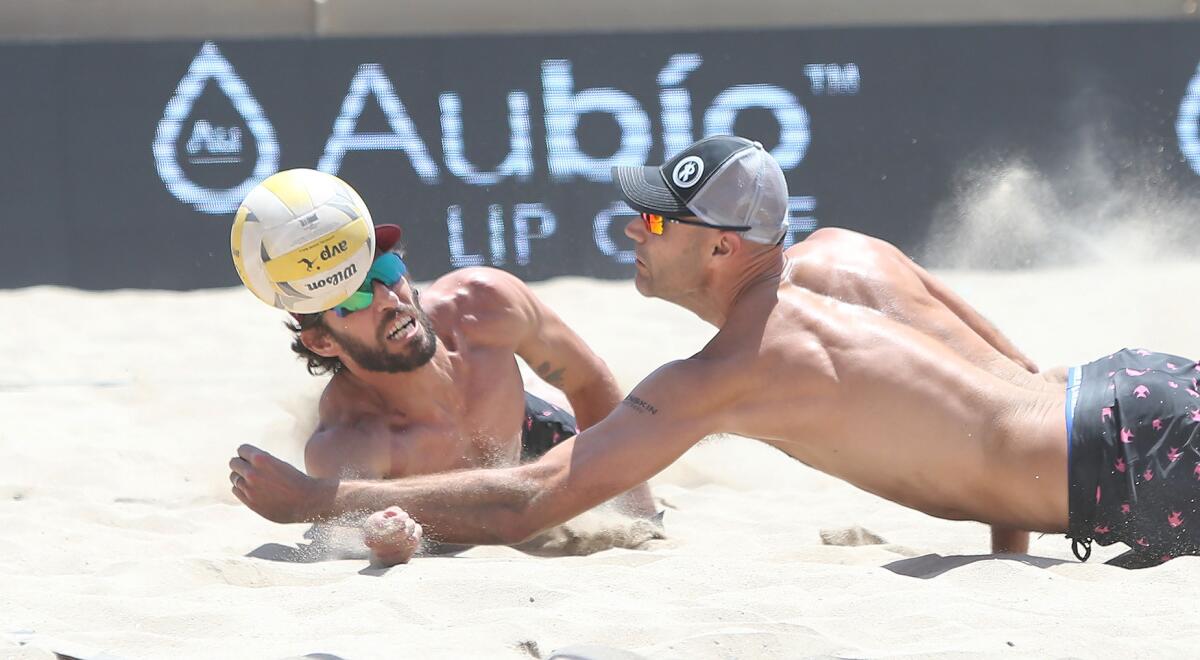 Nick Lucina, left, and Phil Dalhausser, nearly collide as they dig a short shot during the Huntington Beach Open in May.