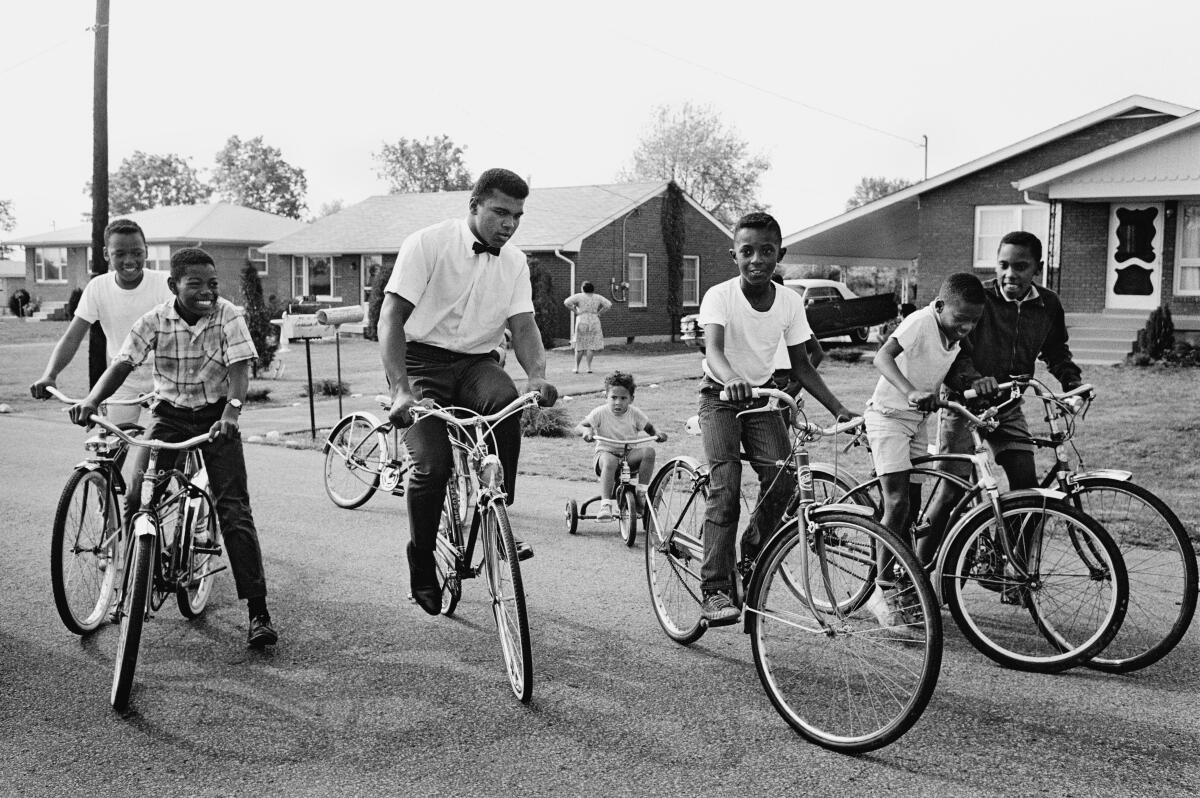 A man goes for a bike ride with a group of children.