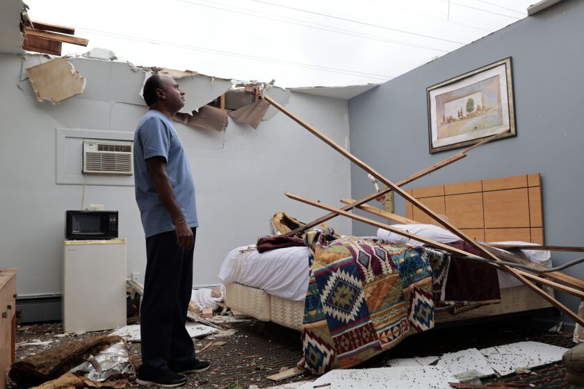 Brian Patel observa los daños causados por los fuertes vientos en una habitación del Motel Skyline en el poblado suburbano de McCook, Illinois, el jueves 13 de julio de 2023. (Antonio Perez/Chicago Tribune vía AP)