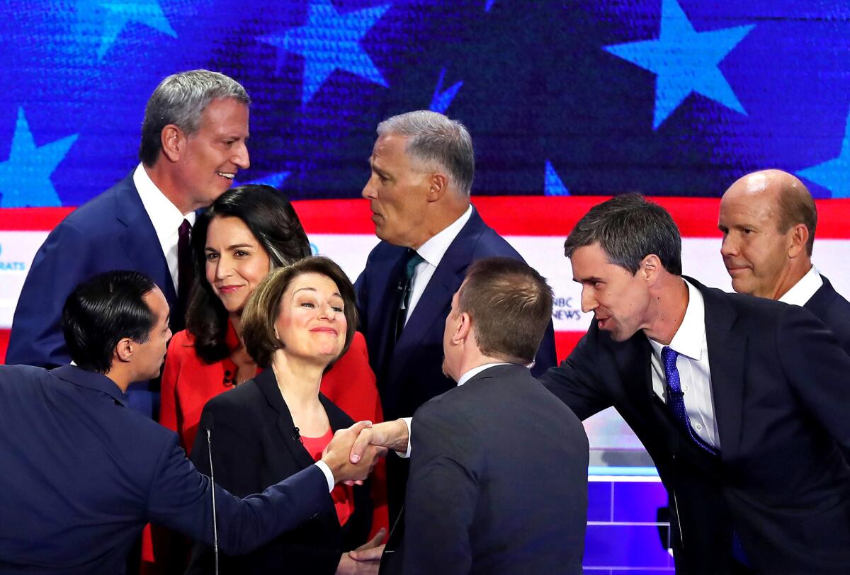 Democratic presidential candidates shake hands and greet moderator Chuck Todd of NBC News, center, after the first night of the party's first primary debate last month.