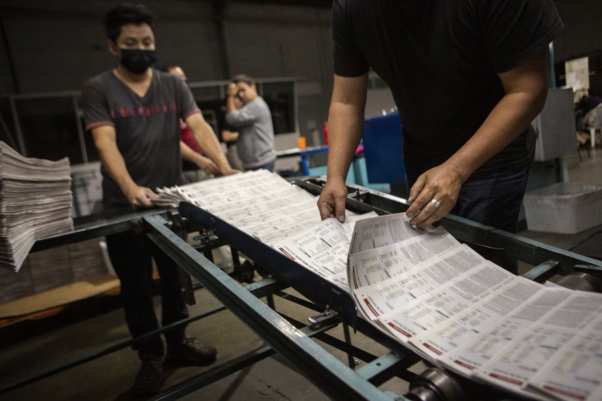 A worker at the el Periodico newspaper's printing press reviews last details before they are packed for distribution