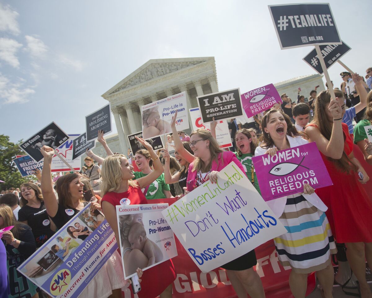 Demonstrators react to hearing the Supreme Court's decision on the Hobby Lobby case outside the court in Washington.