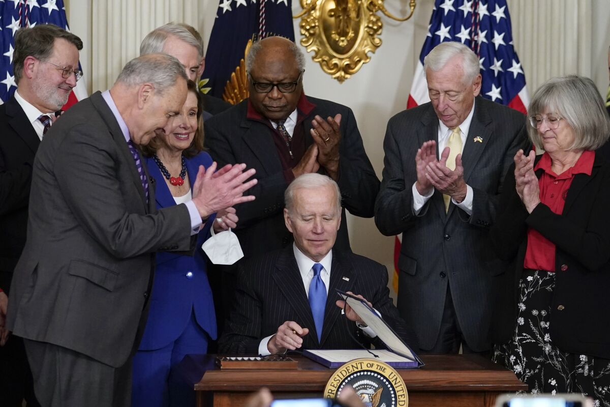 President Joe Biden signs the Postal Service Reform Act.