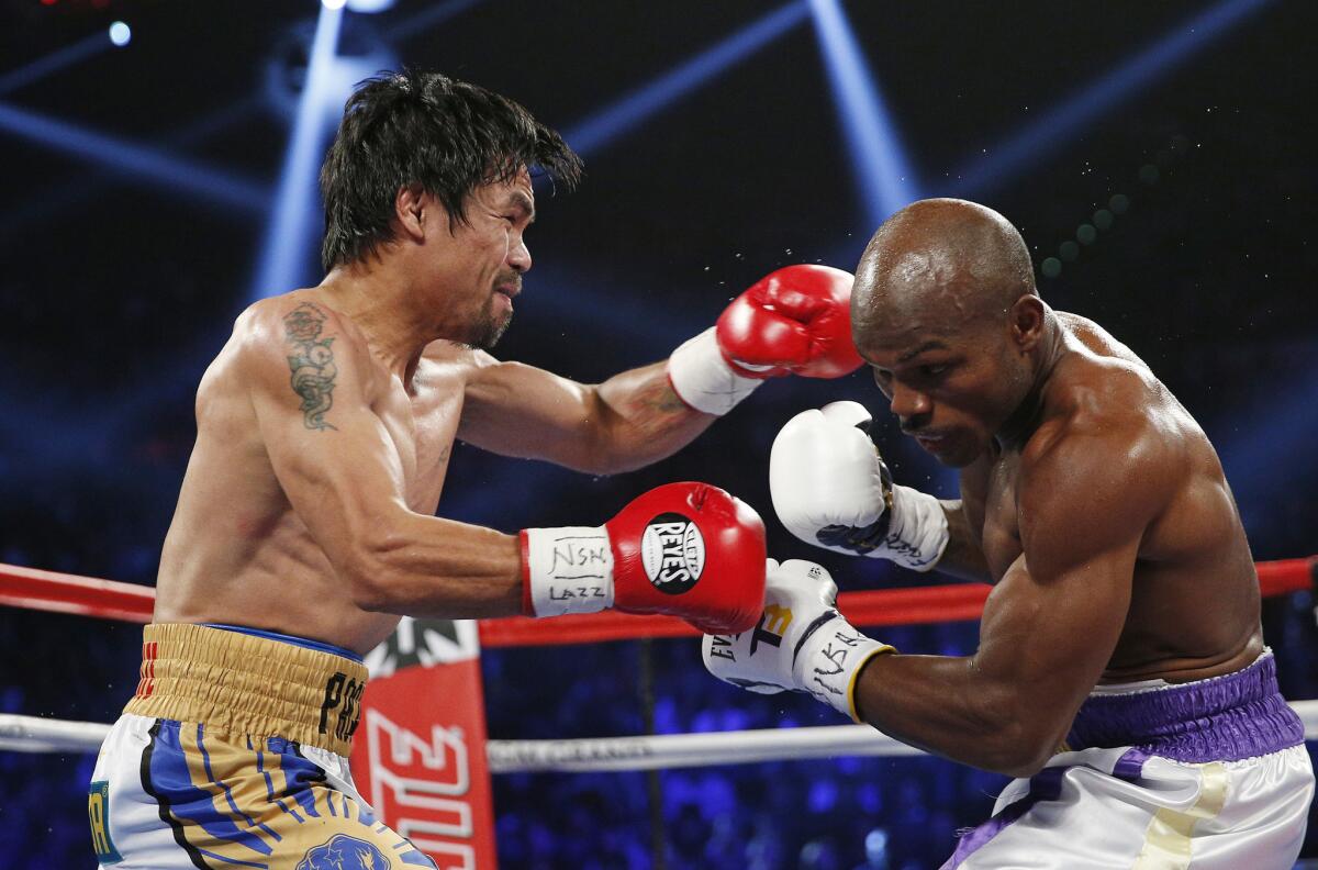 Manny Pacquiao, left, and Timothy Bradley trade punches in the middle of the MGM Grand Garden Arena ring during their WBO welterweight title fight on April 9.