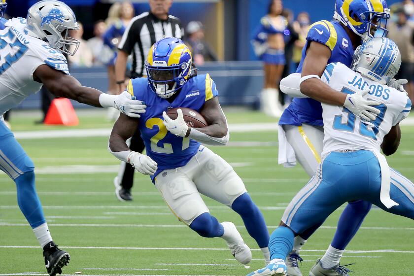 INGLEWOOD, CALIF. - OCT. 24, 2021. Rams tunning back Darrell Henderson Jr. looks for room to run against the LIons in the first quarter at SoFi Stadium in Inglewood on Sunday, Oct. 24, 2021. (Luis Sinco / Los Angeles Times)