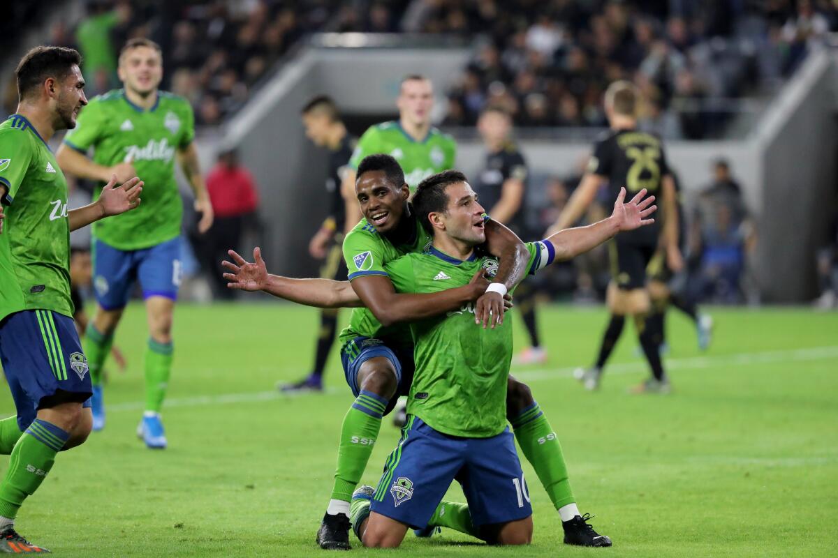 Seattle Sounders' Nicolás Lodeiro gets a hug from Joevin Jones after Lodeiro scores against LAFC on Oct. 29, 2019.