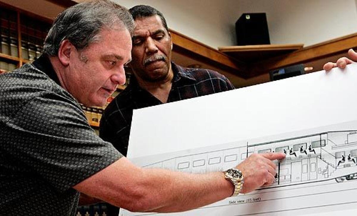 During a news conference at a Los Angeles law firm, Nick Cotsis points to where he was sitting when the Metrolink train crashed into a freight train Sept. 12 in Chatsworth. Next to him is Richard Myles, who was also on the commuter train that day.