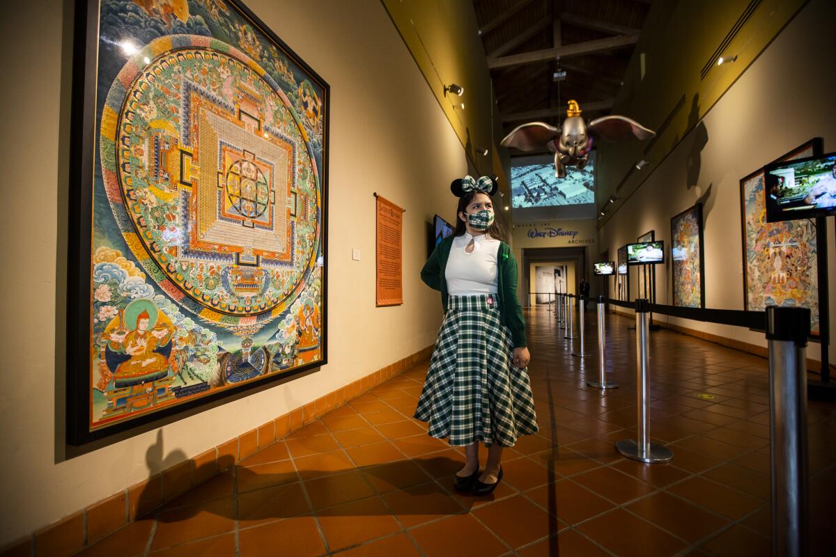 SANTA ANA, CA - March 17: Lali Cervantes, 13, of Covina, views the exhibit: Sacred Realms: Temple Murals by Shashi Dhoj Tulachan From the Gayle and Edward P. Rossi Collection during the grand reopening of the Bowers Museum, following the easing of pandemic restrictions Wednesday, March 17, 2021 in Santa Ana.
