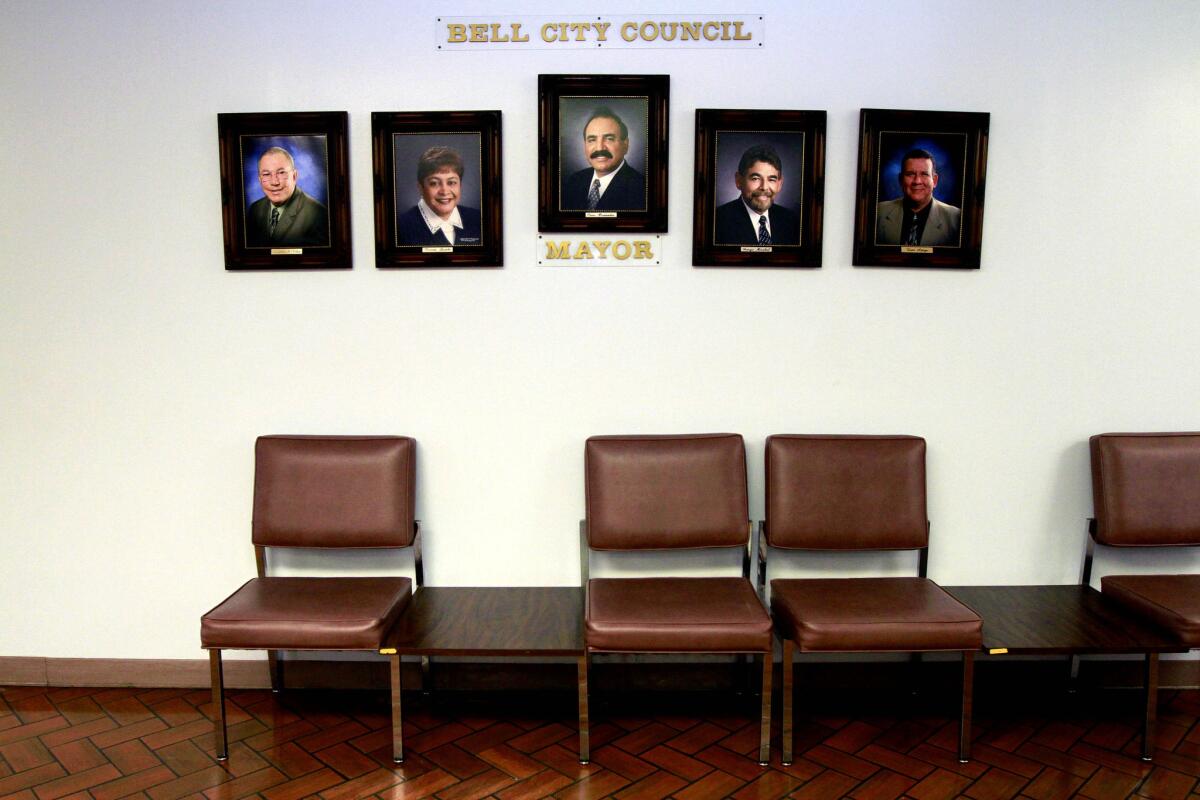 Photos of City Council member Lorenzo S. Velez, Vice Mayor Teresa Jacobo, City of Bell Mayor Oscar Hernandez, City Council member George Mirabal, and City Council member Luis Artiga hang inside the Bell City Hall building.