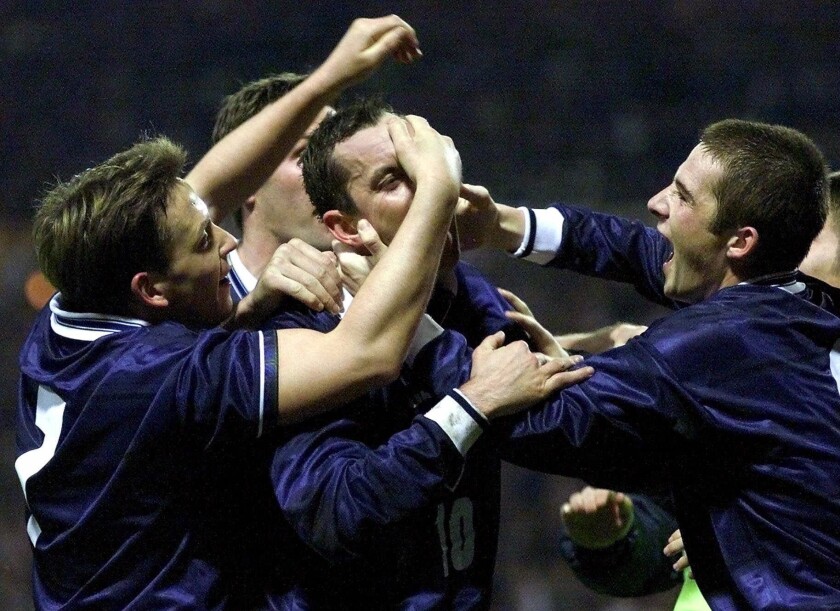 FILE - In this Wednesday, Nov. 17, 1999 file photo, Scotland's Don Hutchinson, center, is mobbed by teammates after scoring against England in their European Championship second leg, playoff soccer qualifier at London's Wembley stadium. The European Championship sees the 115th instalment of international soccer's oldest rivalry when England plays Scotland at Wembley Stadium on Friday June 18, 2021, 149 years after the first match between the two nations.(AP Photo/Max Nash, File)