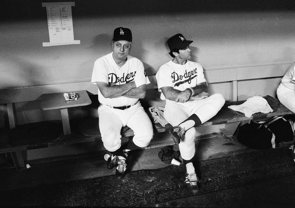 Dodgers manager Tom Lasorda and first baseman Steve Garvey sit in the dugout.