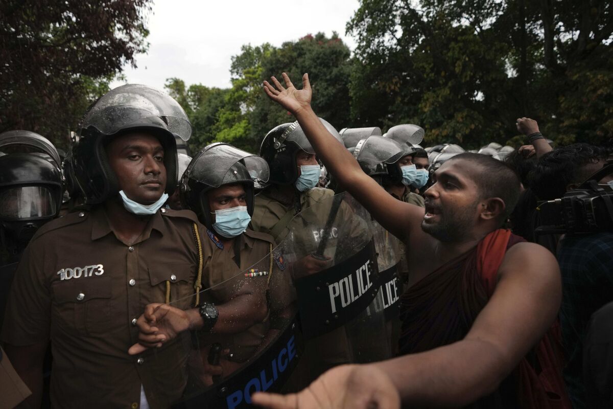 A Sri Lankan undergraduate Buddhist monk shouts slogans demanding president Gotabaya Rajapaksa's resignation during a protest near parliament in Colombo, Sri Lanka, Friday, April 8, 2022. Sri Lankan business leaders on Friday called for an end to political instability amid public demands for the president to resign over alleged economic mismanagement, warning that failure to do so would lead to economic catastrophe. (AP Photo/Eranga Jayawardena)