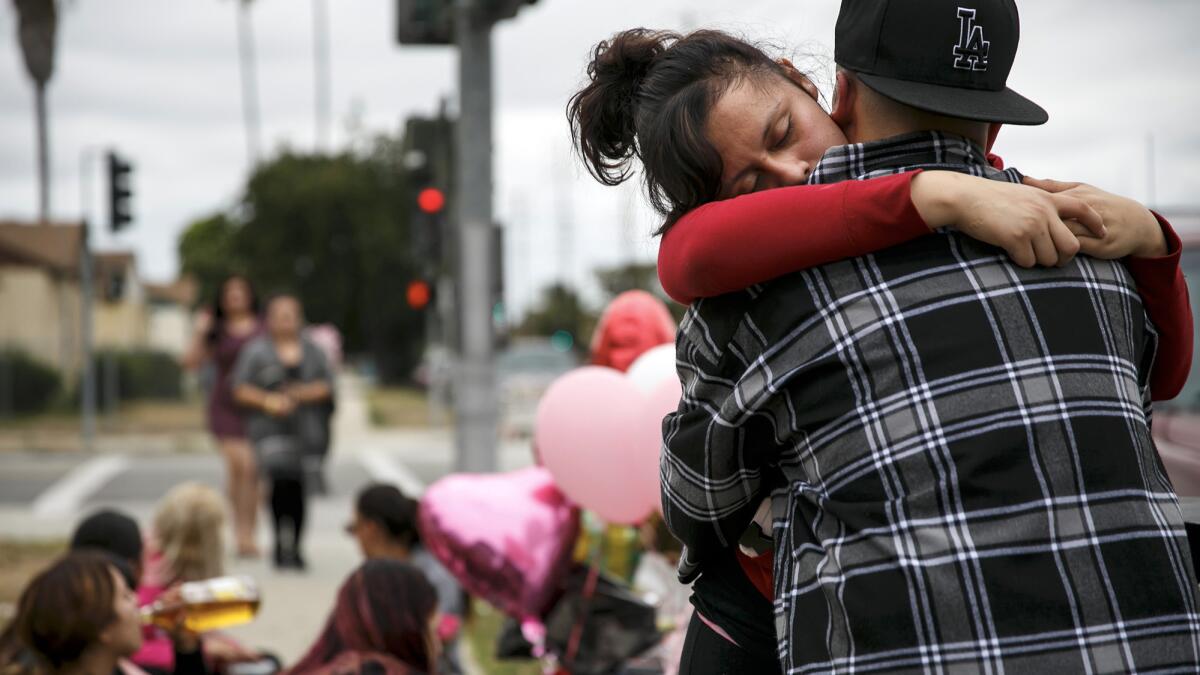 Miriam Ambriz gets a hug as she mourns the loss of her sister Cynthia Ambriz, 19, who was shot and killed in Carson on Saturday.