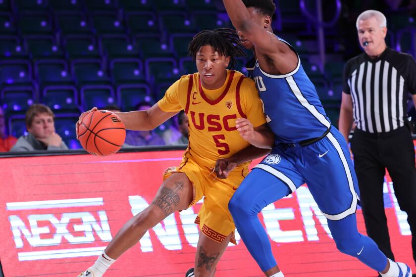 In a photo provided by Bahamas Visual Services, Southern California's Boogie Ellis drives against BYU's Jaxson Robinson during an NCAA college basketball game in the Battle 4 Atlantis at Paradise Island, Bahamas, Wednesday, Nov. 23, 2022. (Tim Aylen/Bahamas Visual Services via AP)