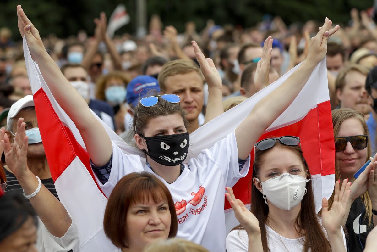 FILE - In this file photo taken on Sunday, July 19, 2020, Belarusians, some of them wearing face masks to protect against coronavirus, attend a meeting in support of Svetlana Tikhanovskaya, candidate for the presidential elections, in Minsk, Belarus. Previously apolitical, Kseniya Milya was among those who flocked to campaign rallies of Sviatlana Tsikhanouskaya, a 37-year old ex-teacher and wife of a jailed opposition blogger, who is challenging Lukashenko in Sunday's vote. (AP Photo/Sergei Grits)