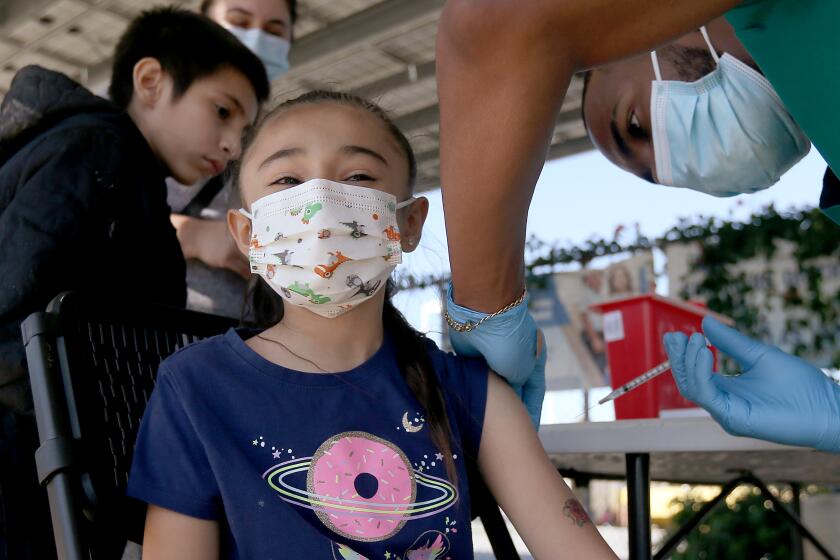 Amaya Palestino, 6, gets immunized with the Pfizer vaccine at Hellen Keller Elementary School in Lynwood in March 2022.