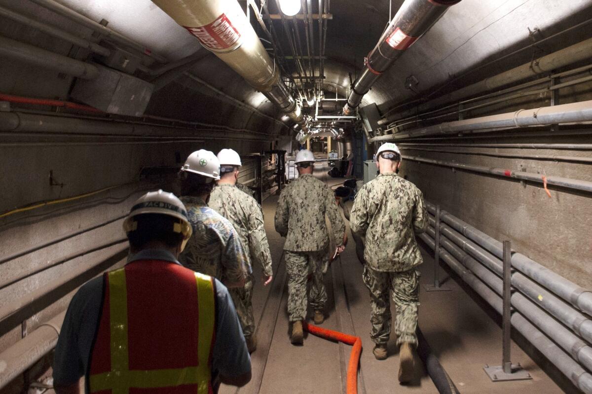 FILE - In this Dec. 23, 2021, photo provided by the U.S. Navy, Rear Adm. John Korka, Commander, Naval Facilities Engineering Systems Command (NAVFAC), and Chief of Civil Engineers, leads Navy and civilian water quality recovery experts through the tunnels of the Red Hill Bulk Fuel Storage Facility, near Pearl Harbor, Hawaii. The Honolulu Board of Water Supply said it has detected a small amount of a chemical naturally occurring in coal, crude oil and gasoline in a monitoring well near a Navy fuel storage facility that spilled jet fuel last year. (Mass Communication Specialist 1st Class Luke McCall/U.S. Navy via AP, File)