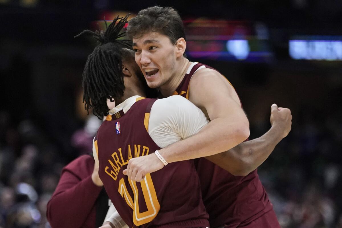 Cleveland Cavaliers' Cedi Osman, right, hugs Darius Garland after the Cavaliers defeated the Boston Celtics 91-89 in an NBA basketball game, Saturday, Nov. 13, 2021, in Cleveland. (AP Photo/Tony Dejak)