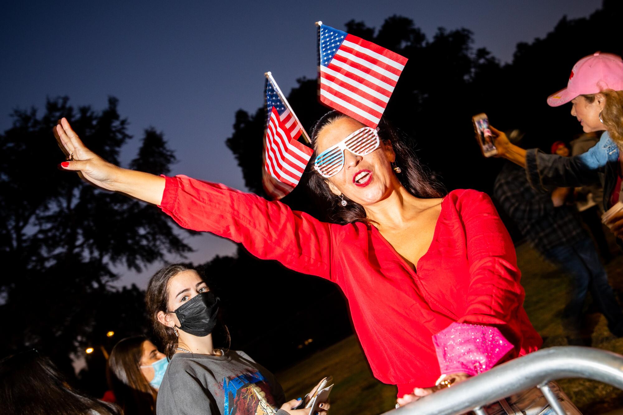 Faviala Raley of Ventura holds up four fingers, signaling four more years for President Trump, on Tuesday night.