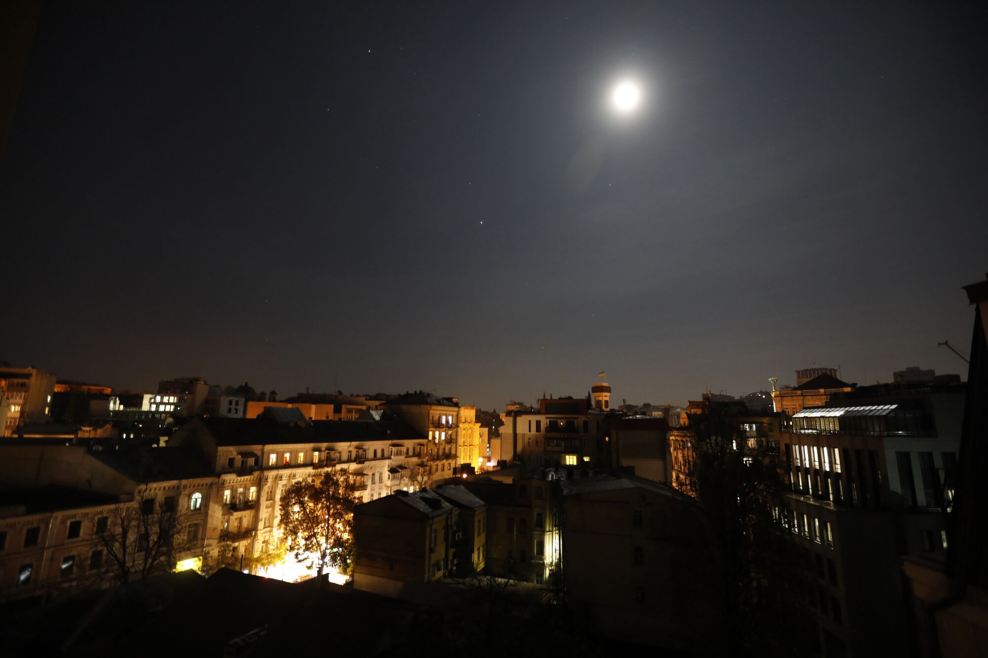 The moon shines bright over downtown Kyiv, helping to fend off darkness. 