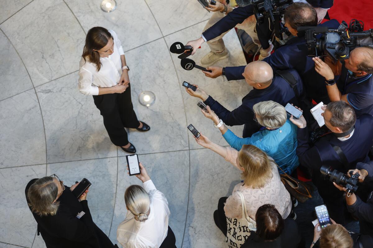 Finnish Prime Minister Sanna Marin pauses as she speaks to reporters.