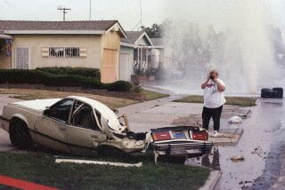 Jeanie Basurto photographs her crushed car after Shawn Nelson drove a tank through Clairemont on May 17, 1995