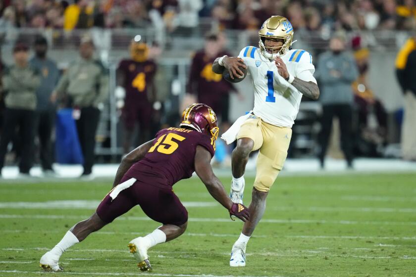 UCLA quarterback Dorian Thompson-Robinson (1) starts his leap over Arizona State defensive back Khoury Bethley (15) during the first half of an NCAA college football game in Tempe, Ariz., Saturday, Nov. 5, 2022. (AP Photo/Ross D. Franklin)