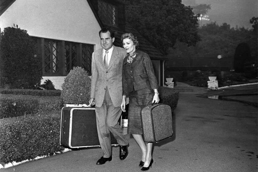 Nov. 6, 1961: Advancing flames force former Vice President Richard Nixon and his wife, Pat, to leave their rented home on Bundy Drive in Brentwood. Before leaving, Nixon hosed down the roof.(Los Angeles Times )