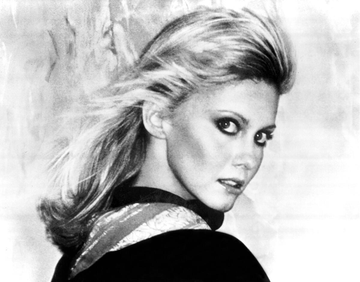 Olivia Newton-John with her hair sultrily blown back in a publicity photo.