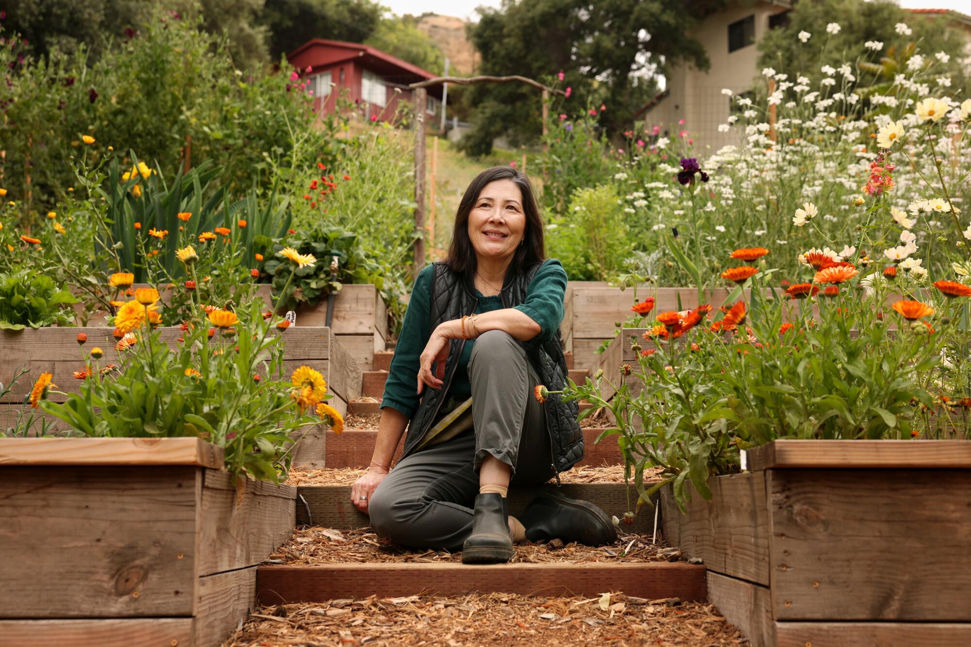 L.A. landscape designer Kathleen Ferguson sits surrounded by flowers in wooden planter boxes
