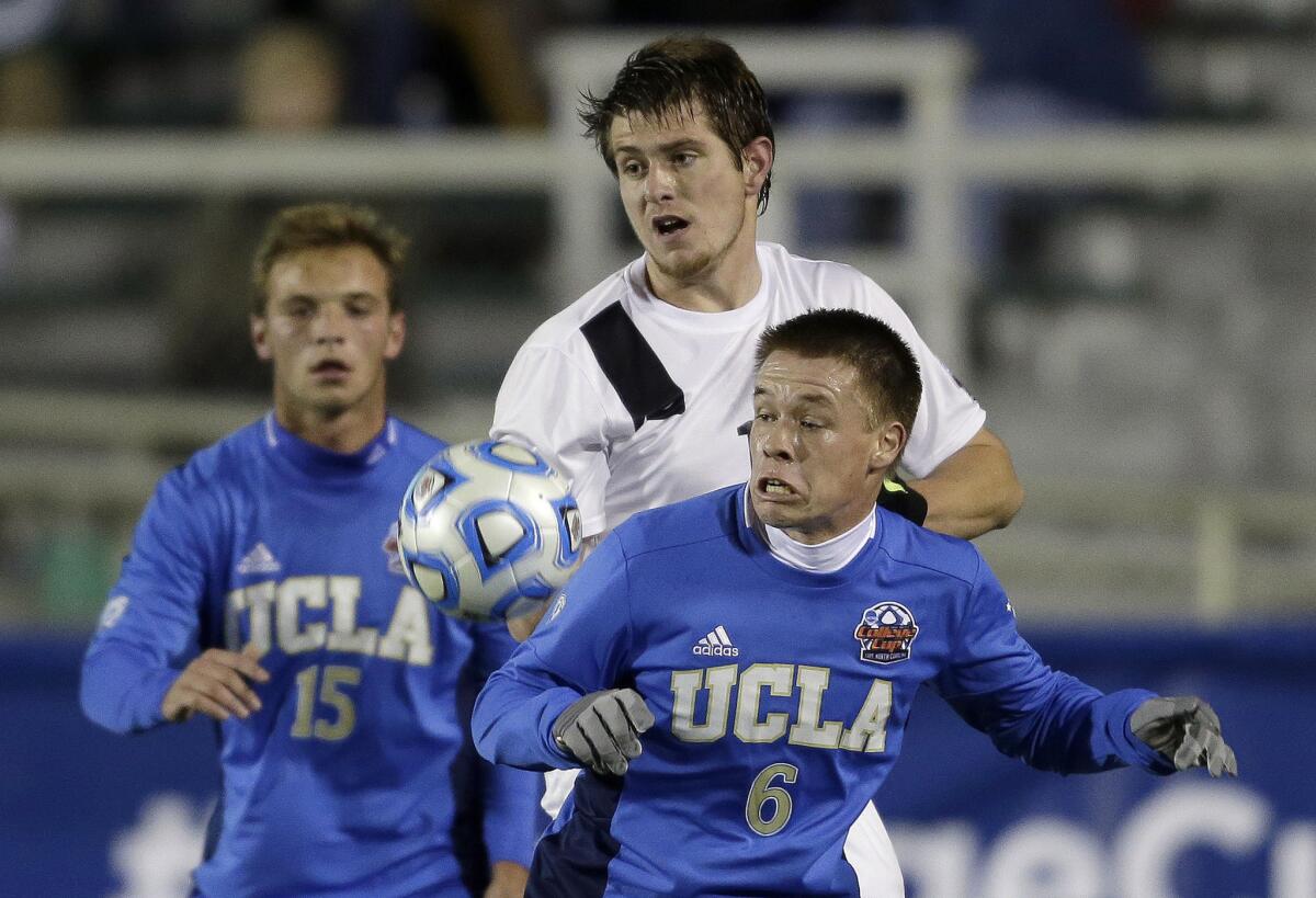 Providence's Mac Steeves, center, struggles with UCLA's Jordan Vale (6) and Chase Gasper (15) during the first half of the Bruins' overtime win over the Friars, 3-2, in overtime.
