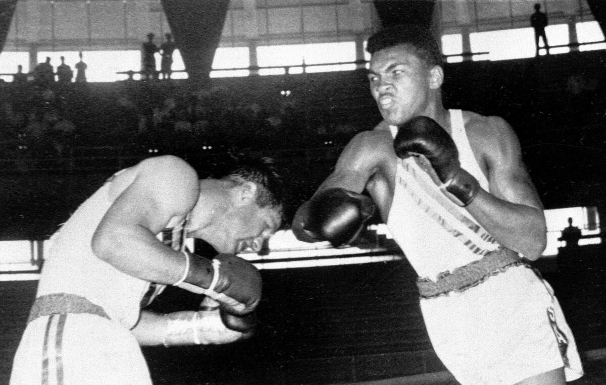 FILE - In this Sept. 3, 1960, file photo, Cassius Clay, 18-year-old from Louisville, Ky., throws a right at Tony Madigan of Australia, left, during the light heavyweight boxing semi-finals at the Summer Olympic Games in Rome. The 1960 Rome Summer Olympics set the standard for every Olympiad to follow. These Games were the first televised in the United States (AP Photo/File)