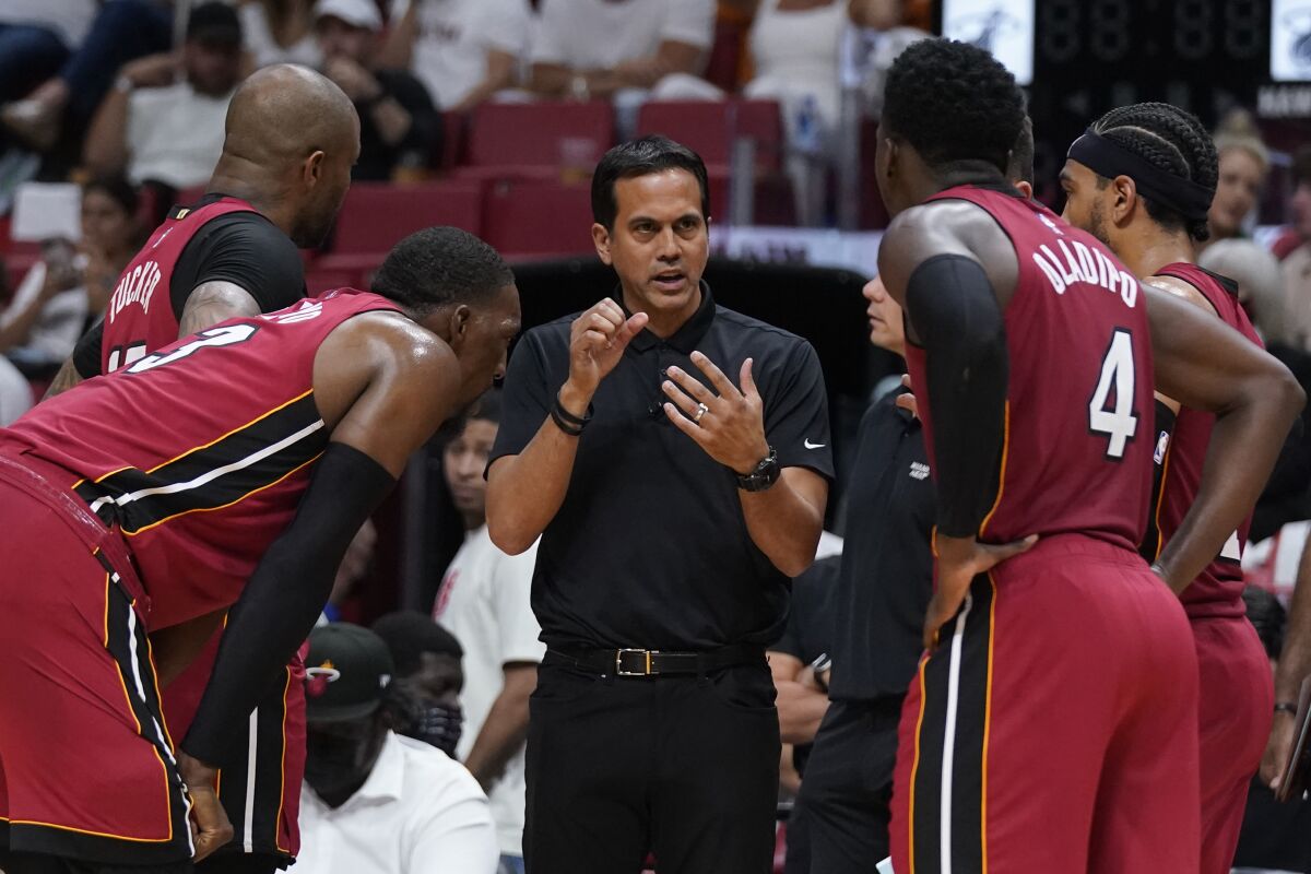 Miami Heat head coach Erik Spoelstra, center, talks with players as officials review a play during the second half of Game 5 of an NBA basketball first-round playoff series against the Atlanta Hawks, Tuesday, April 26, 2022, in Miami. (AP Photo/Wilfredo Lee)