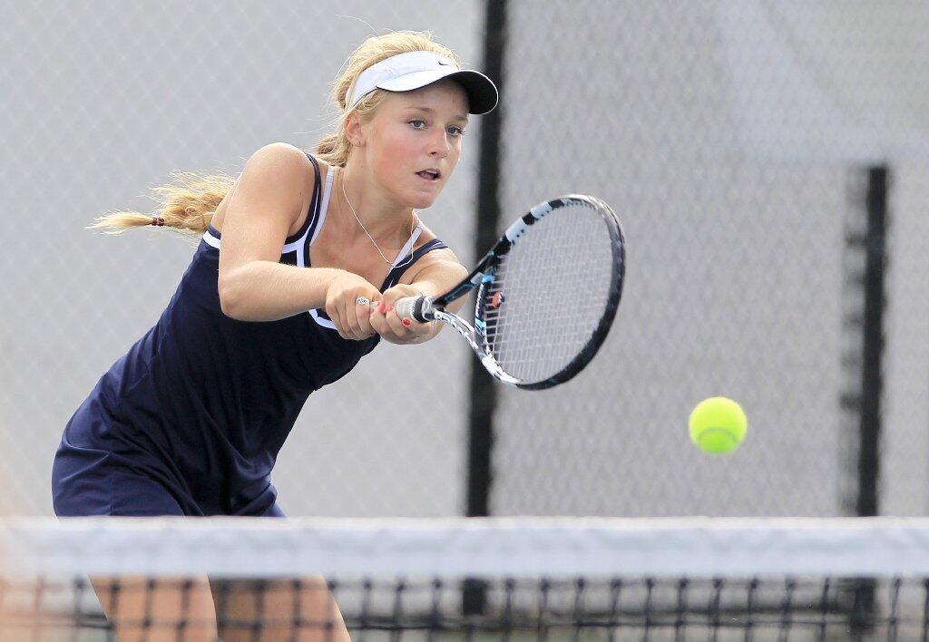 Newport Harbor High's Anna Burke plays at the net in a doubles set against Corona del Mar during the Battle of the Bay match on Tuesday.
