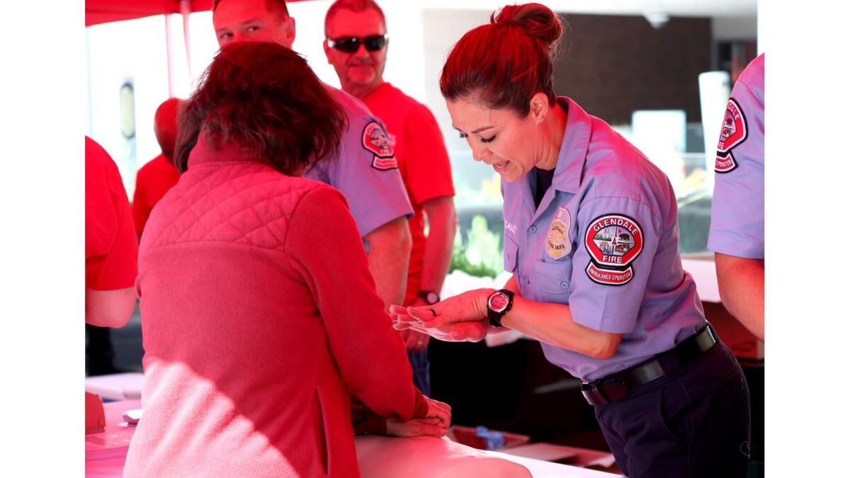 Glendale Fire Department Ambulance Operator Celine Gonzalez shows Manuela Fernandez how to properly perform hands-only CPR during Sidewalk CPR Day on Thursday, June 6, 2019.