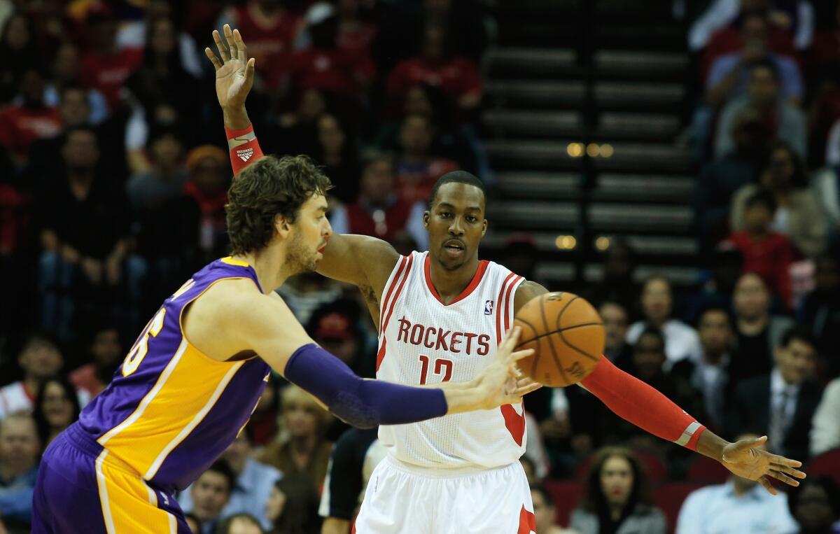 Lakers forward Pau Gasol, left, passes in front of Houston Rockets center Dwight Howard during Thursday's game.