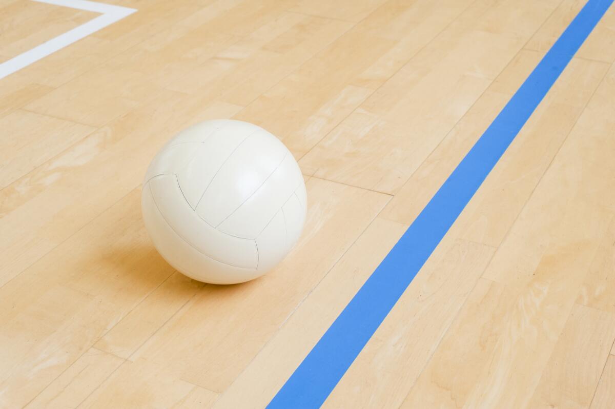 Volleyball ball on hardwood volleyball court.