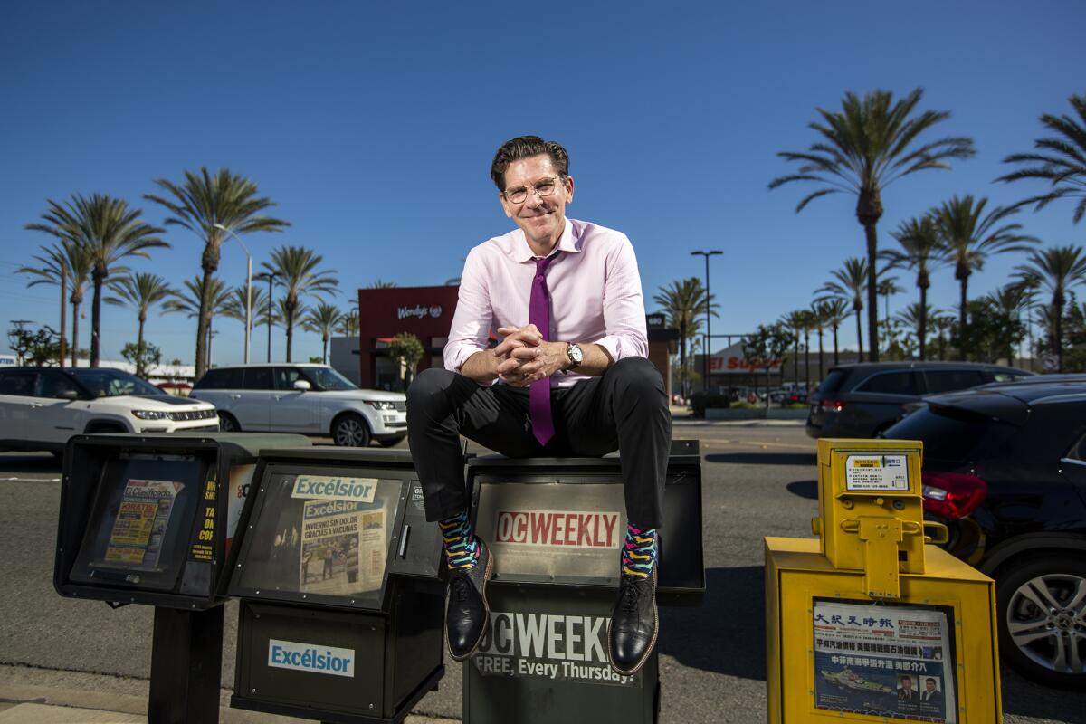 Will Swaim, the founder and former editor of the OC Weekly, poses by an old newspaper rack in Anaheim.