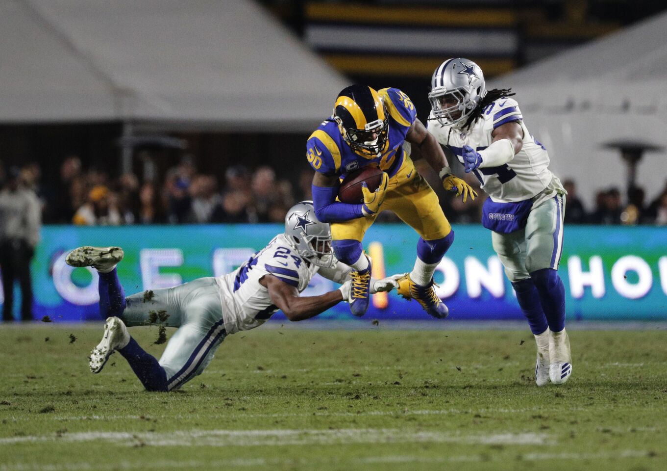 Rams running back Todd Gurley (30) leaps through the tackle of Cowboys cornerback Chidobe Awuzie (24) and middle linebacker Jaylon Smith (54) during the second half.