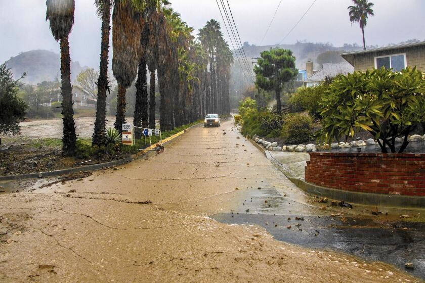 Mud flows down Hicrest Road during heavy rain in Glendora earlier this month. Flood insurance covers mudflow damage, but homeowners and the National Flood Insurance Program sometimes differ on what qualifies as a mudflow.