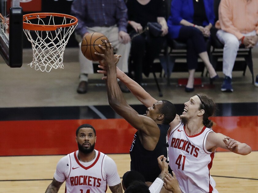 The Clippers' Serge Ibaka, middle, drives to the basket past the Rockets' Kelly Olynyk (41) on May 14, 2021, in Houston. 