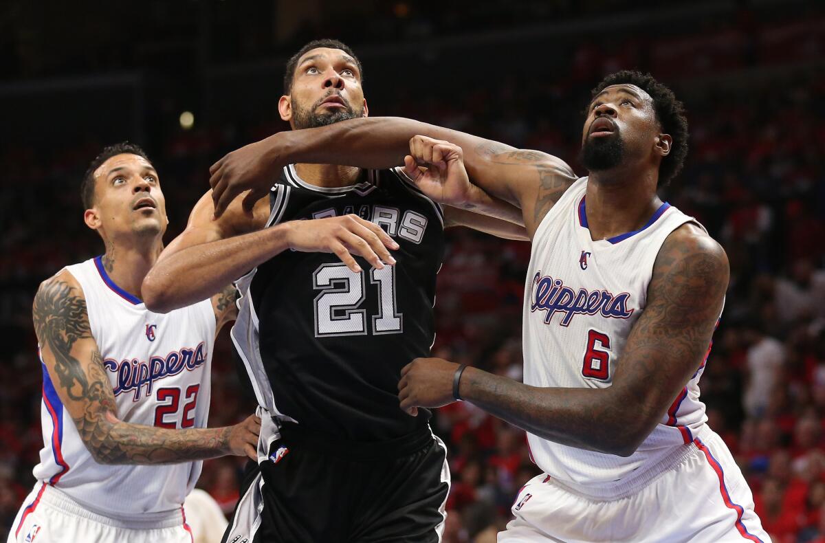 San Antonio's Tim Duncan (21) battles for rebound position with Clippers DeAndre Jordan (6) and Matt Barnes on Sunday.