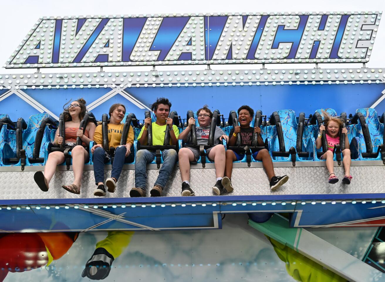 Children experience the thrill of a drop in the Avalanche ride during the carnival at Reese & Community Volunteer Fire Company on Tuesday, July 16.