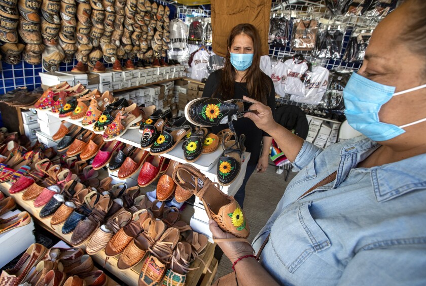 Huarache vendor Maria Silva helps customer Ana Rosa Ornelas of Sacramento.