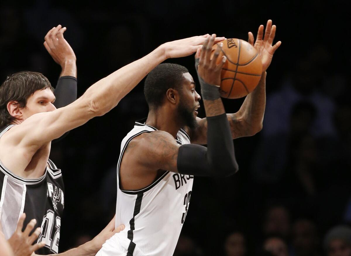 Spurs center Boban Marjanovic (40) knocks the ball loose from the hands of Nets forward Willie Reed (33) in the second half.