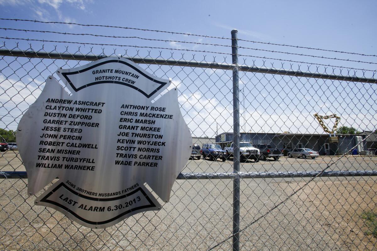 A plaque with the names of the 19 fallen firefighters from the Granite Mountain hotshot crew hangs on the gate of Fire Station 7 in Prescott, Ariz.