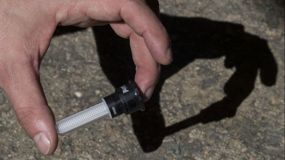 Marco Schiavon, a professional researcher at UC Riverside, holds the preferable spray nozzle with filter attached for use in sprinkler systems.