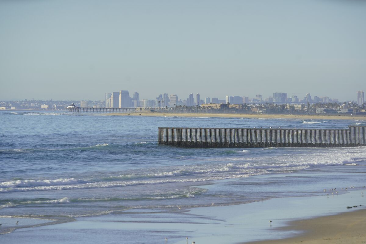 A border fence and San Diego's skyline as seen from Tijuana. The cities together are seeking to be World Design Capital.