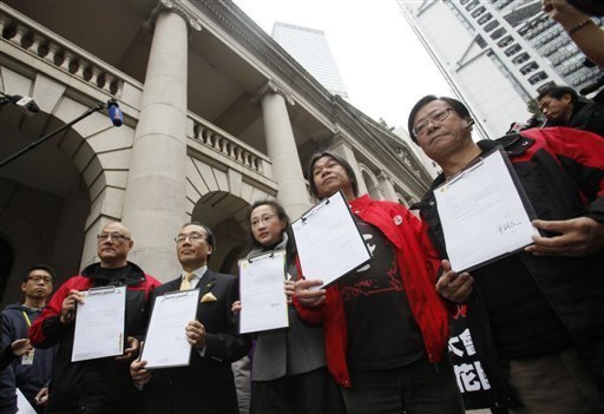 Five Hong Kong legislators, from left, Albert Chan, Alan Leong, Tanya Chan, Leung Kwok-hung and Wong Yuk-man hold the resignation letter outside the Legislative Council in Hong Kong Tuesday, Jan. 26, 2010. The five legislators have resigned to pressure China for democracy in this semiautonomous former British colony. The lawmakers from the League of Social Democrats and Civic Party signed and held up their resignation letters for photographers Tuesday, then handed them to the secretary of Hong Kong's Legislative Council. (AP Photo/Kin Cheung)