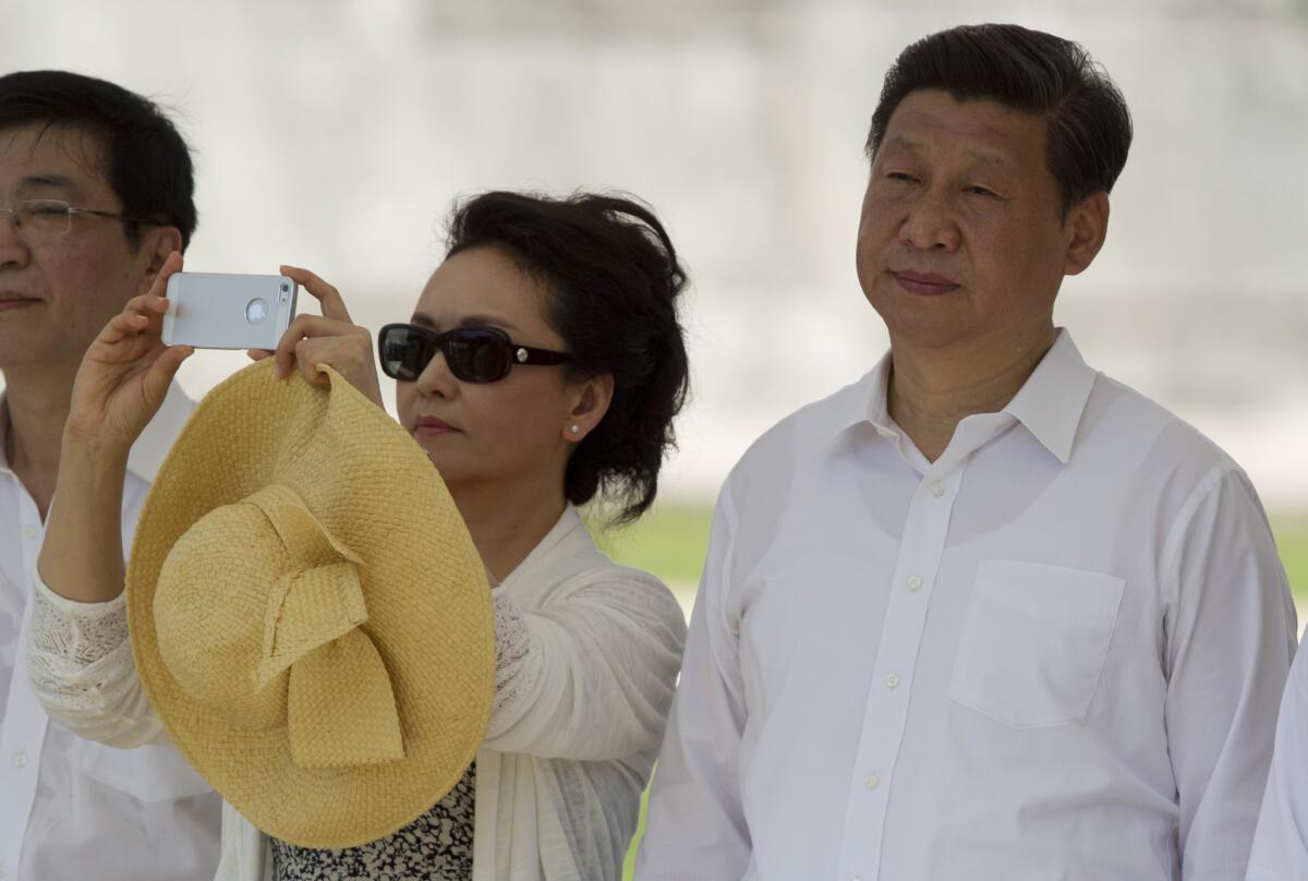 China's President Xi Jinping, right, watches a folk dance presentation as his wife, Peng Liyuan, takes a photograph near the Mayan ruins of Chichen Itza in southern Mexico.